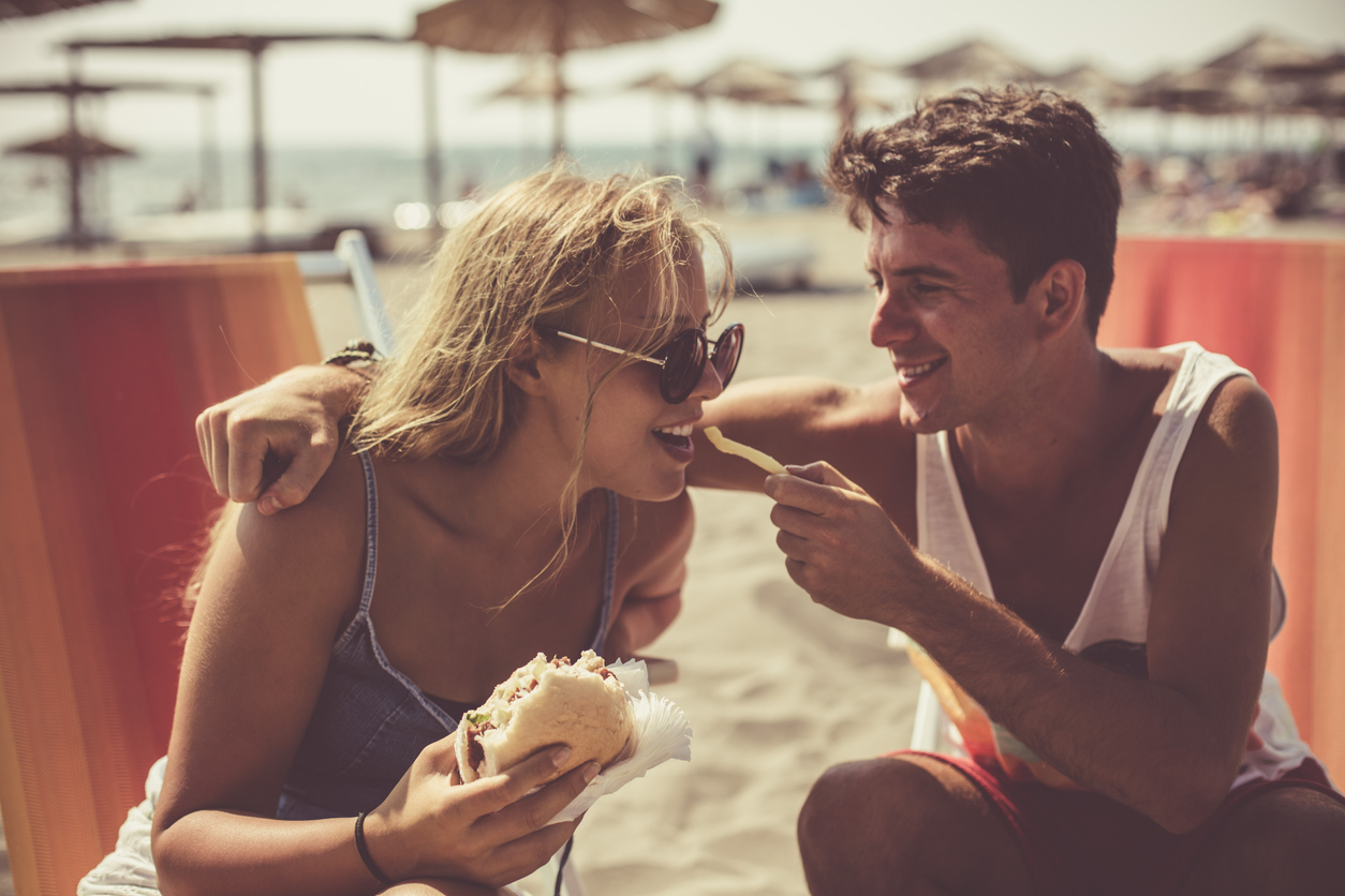 young couple eating lunch on beach