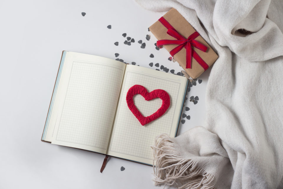 White Scarf, Gift, Heart and Diary on a White Background. Copy space. Flat, top view