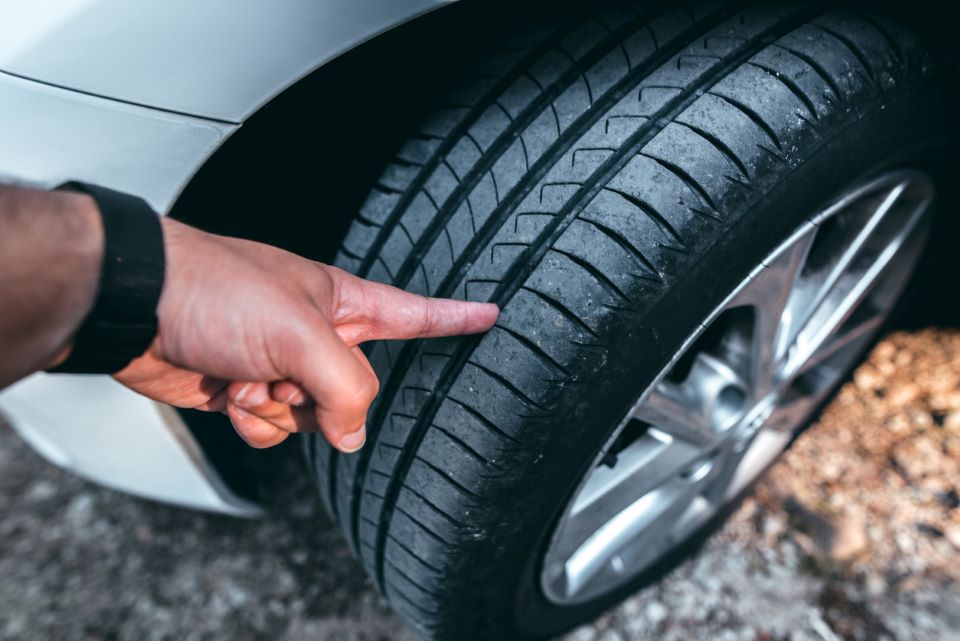 Man pointing at the tread on a tire