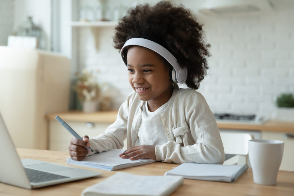 Little girl smiling while working on homework